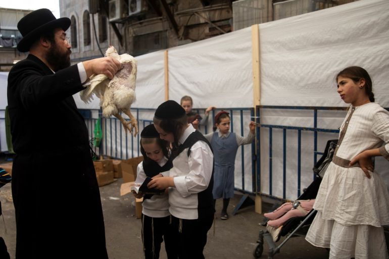 Children take part as an ultra-Orthodox Jewish man performs the Kaparot ritual, where white chickens are slaughtered as a symbolic gesture of atonement, ahead of Yom Kippur, the Jewish Day of Atonement, in Jerusalem's Mea Shearim neighbourhood October 6, 2019. REUTERS/Ronen Zvulun