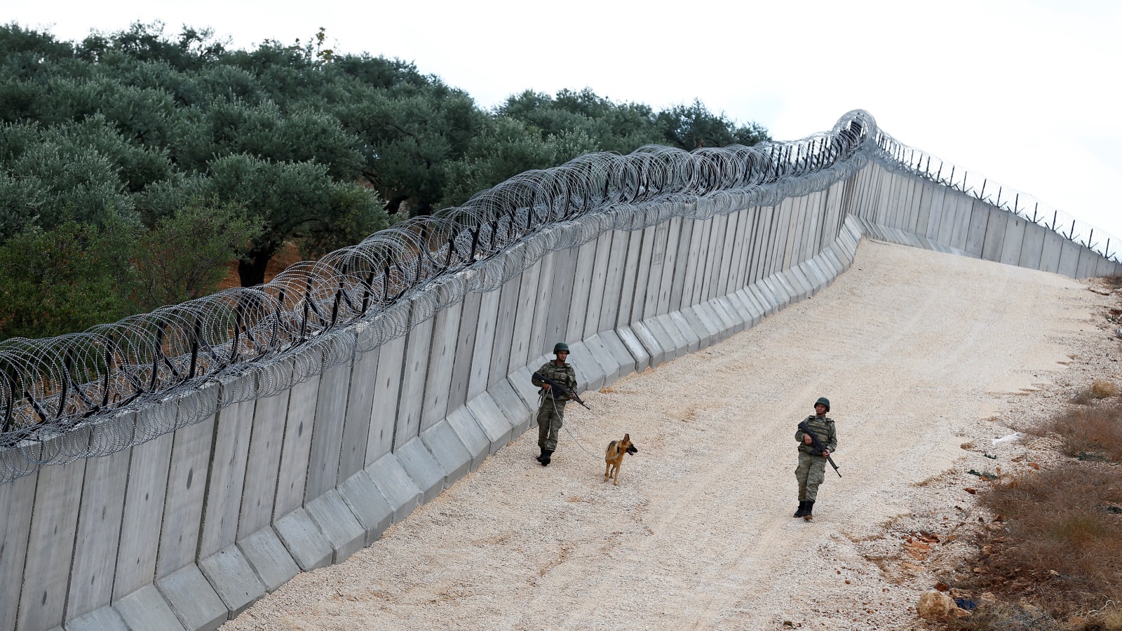 ‪جنديان تركيان يقوم بجولة تفتيش عند الجدار الحدودي مع سوريا في محافظة هاتاي‬ (رويترز)