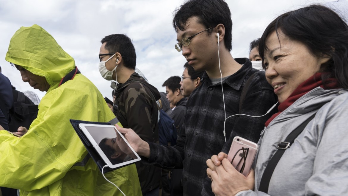 TOKYO, JAPAN - OCTOBER 22: Well-wishers watch a live broadcast of the enthronement ceremony of Japan's Emperor Naruhito on a tablet computer outside the Imperial Palace on October 22, 2019 in Tokyo, Japan. Emperor Naruhito proclaimed his enthronement today. (Photo by Tomohiro Ohsumi/Getty Images)