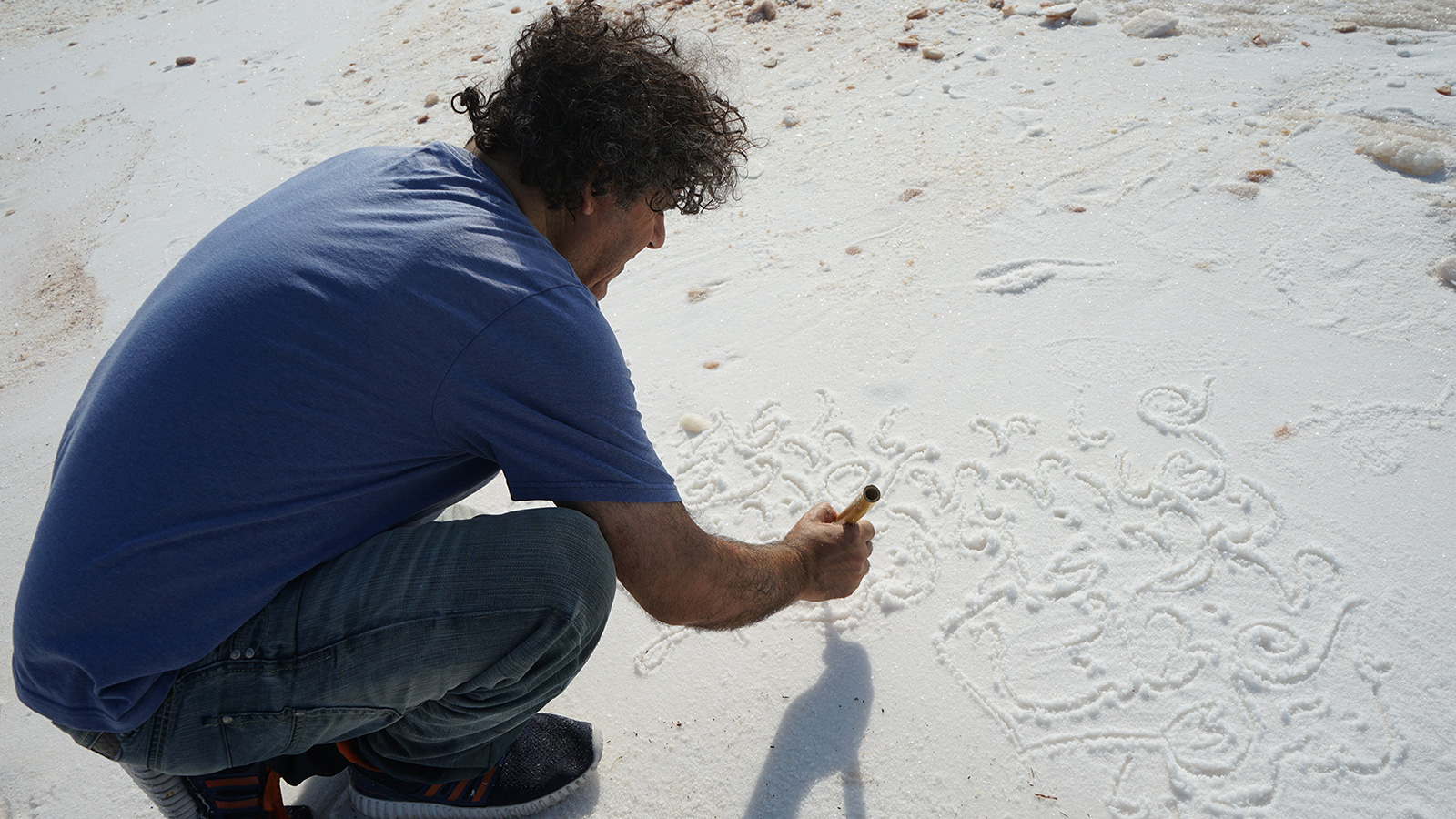 ‪خط الفنان التشكيلي أبو عزيز أكثر من خمسين عملا على شواطئ الملح‬ (الجزيرة)