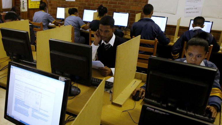 Students use computers to study at Elswood Secondary School in Cape Town November 7, 2013. Even the metal grills welded into its walls did not deter burglars from ripping out the copper cables that delivered Internet to the students of this tough neighbourhood. But Elswood's pupils were saved by alternative technology - free wireless connection via unused TV spectrum known as white space. It's being provided by a consortium including Google as part of a wider trial. Elsewhere in the country Microsoft is operating similar pilots. Both are racing to fine tune a technology that could ultimately bring cheap broadband to the entire continent. Picture taken November 7, 2013. To match Feature AFRICA-INTERNET/ REUTERS/Mike Hutchings (SOUTH AFRICA - Tags: EDUCATION BUSINESS SCIENCE TECHNOLOGY)