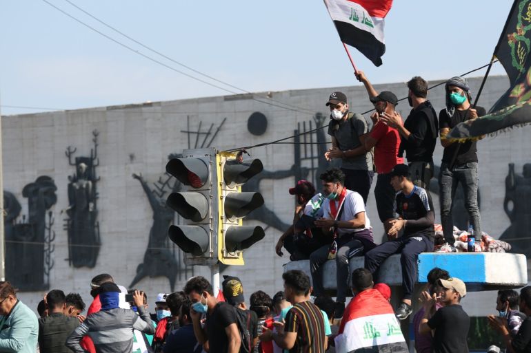 Anti-govt demonstrations in Iraq- - BAGHDAD, IRAQ - OCTOBER 26 : Protesters wave flags during a protest against unemployment, corruption and lack of public services, at Tahrir Square in Baghdad, Iraq on October 26, 2019.