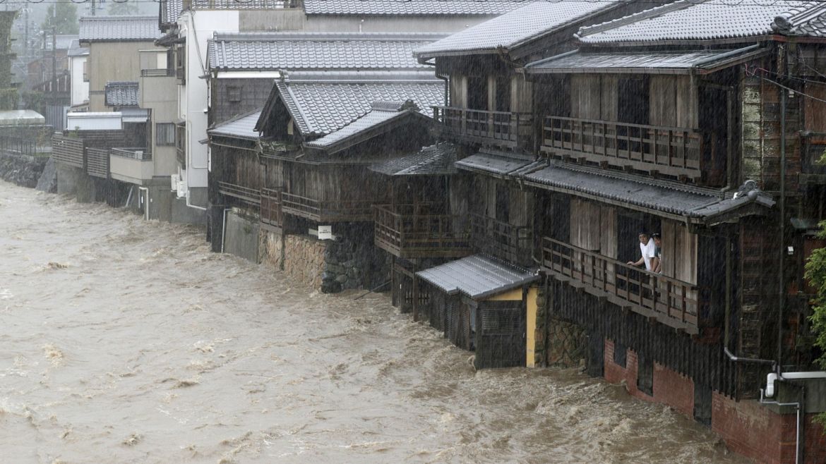 Men watch the swollen Isuzu River due to heavy rain caused by Typhoon Hagibis in Ise, central Japan, in this photo taken by Kyodo October 12, 2019.  Mandatory credit Kyodo/via REUTERS ATTENTION EDITORS - THIS IMAGE WAS PROVIDED BY A THIRD PARTY. MANDATORY CREDIT. JAPAN OUT. NO COMMERCIAL OR EDITORIAL SALES IN JAPAN.