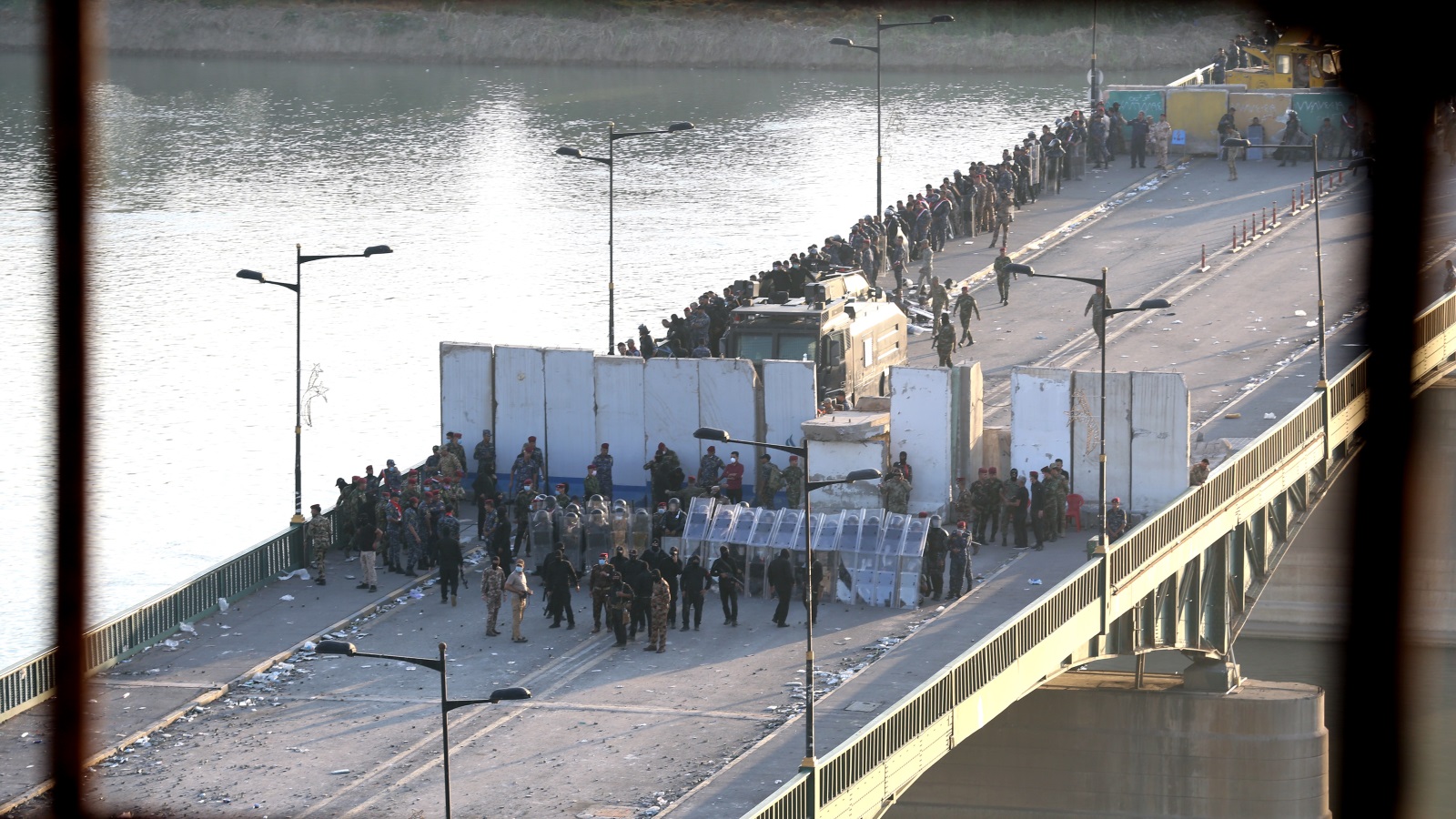 قوات عراقية تغلق أحد الجسور أمام المتظاهرين لمنعهم من الوصول إلى المنطقة الخضراء (الأناضول)