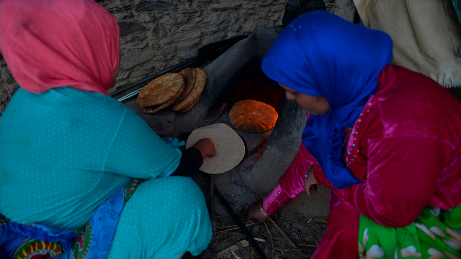 ‪امرأة تخبز في فرن طيني بإحدى القرى‬ (الجزيرة)