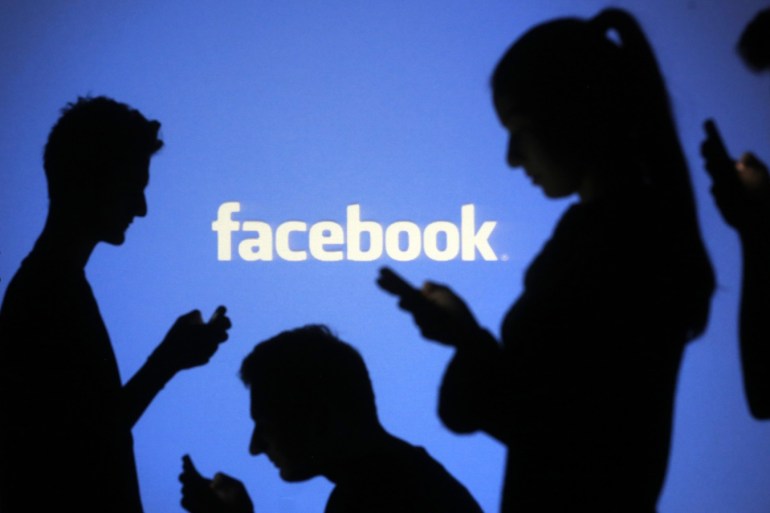 People are silhouetted as they pose with mobile devices in front of a screen projected with a Facebook logo, in this picture illustration taken in Zenica October 29, 2014. Facebook Inc warned on Tuesday of a dramatic increase in spending in 2015 and projected a slowdown in revenue growth this quarter, slicing a tenth off its market value. Facebook shares fell 7.7 percent in premarket trading the day after the social network announced an increase in spending in 2015 and projected a slowdown in revenue growth this quarter.   REUTERS/Dado Ruvic (BOSNIA AND HERZEGOVINA  - Tags: BUSINESS SCIENCE TECHNOLOGY BUSINESS LOGO)