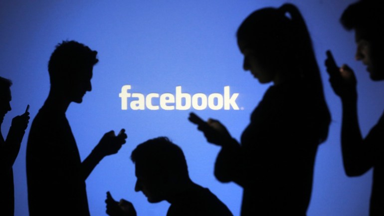 People are silhouetted as they pose with mobile devices in front of a screen projected with a Facebook logo, in this picture illustration taken in Zenica October 29, 2014. Facebook Inc warned on Tuesday of a dramatic increase in spending in 2015 and projected a slowdown in revenue growth this quarter, slicing a tenth off its market value. Facebook shares fell 7.7 percent in premarket trading the day after the social network announced an increase in spending in 2015 and projected a slowdown in revenue growth this quarter. REUTERS/Dado Ruvic (BOSNIA AND HERZEGOVINA - Tags: BUSINESS SCIENCE TECHNOLOGY BUSINESS LOGO)