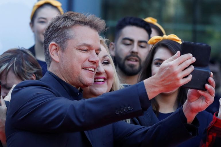 Actor Matt Damon poses with a fan as he arrives at the international premiere of