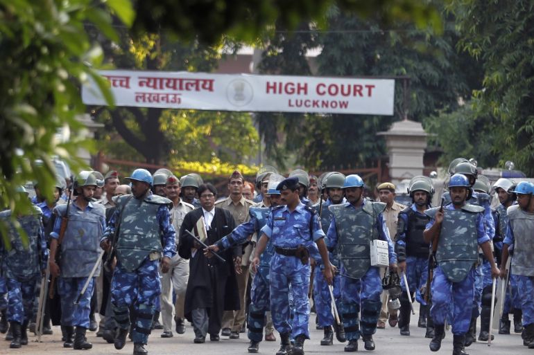 Paramilitary soldiers escort the lawyers of Sunni Central Waqf Board and All Babri Masjid Action Committee as they leave the High Court in the northern Indian city of Lucknow September 30, 2010. A court ruled on Thursday the site of the demolished Babri mosque in Ayodhya would be divided between Hindus and Muslims, in a ruling that could appease both groups in one of the country's most divisive cases. REUTERS/Adnan Abidi (INDIA - Tags: POLITICS RELIGION CIVIL UNREST MILITARY IMAGES OF THE DAY)