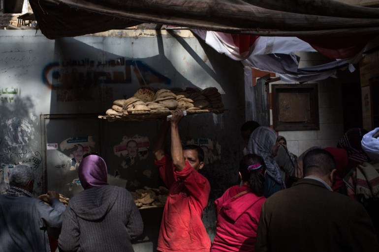 CAIRO, EGYPT - DECEMBER 15: A man carries a tray of freshly baked bread through a crowd of customers outside a bread factory on December 15, 2016 in Cairo, Egypt. Bread prices are said to have tripled in past months. Since the 2011 Arab Spring, Egyptians have been facing a crisis, the uprising brought numerous political changes, but also economic turmoil, increased terror attacks and the unravelling of the once strong tourism sector. In recent weeks Egypt has again been hit by multiple bomb blasts, the most recent killed 26 Christians inside the St Peter and St Paul Church during Sunday mass. As Christians took to the streets chanting anti-government slogans, fears grow of an escalation in militant activity which would further deal damage to a country trying to rebuild. In recent months protests against rising fuel and food prices, calls for mass anti-government demonstrations and the continued terror attacks have seen Egyptian president Abdel Fattah Al-Sisi, suffer a significant drop in popularity. Mr. Al-Sisi has promised change, fearing anger and desperation could lead to popular unrest, however inflation currently sits at the highest level in seven years, jobless rates are above 13percent and more than 90million people are said to be living in poverty. The outlook forced the government to seek a $12 billion bailout from the International Monetary Fund, pushing the country to float the Egyptian pound to qualify for the loan. The move led to a sharp devaluation of the Egyptian pound which now sits at 18EGP to the dollar. The turmoil is affecting not only the poor but both the middle-class and the wealthy as food and commodity prices skyrocket. (Photo by Chris McGrath/Getty Images)