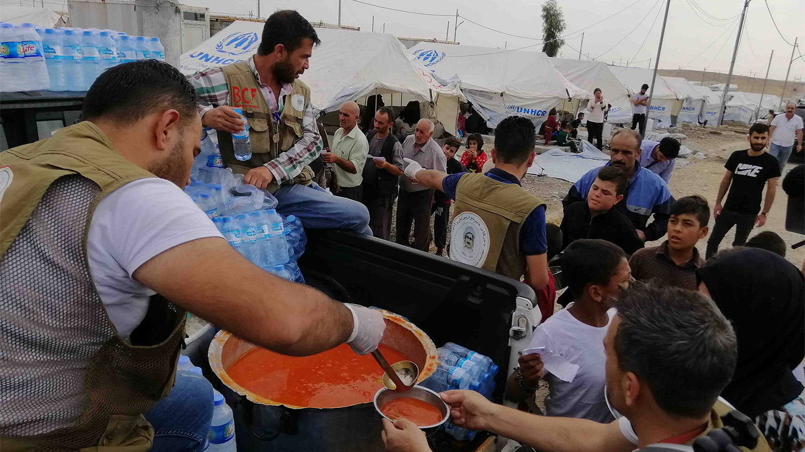 توزيع الطعام على اللاجئين في مخيم بردرش (الجزيرة نت)