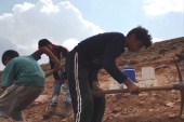 أحمد وشقيقه وطفل ثالث يحفرون قبرا لمتوفٍ جديد (الجزيرة نت-أرشيف)
