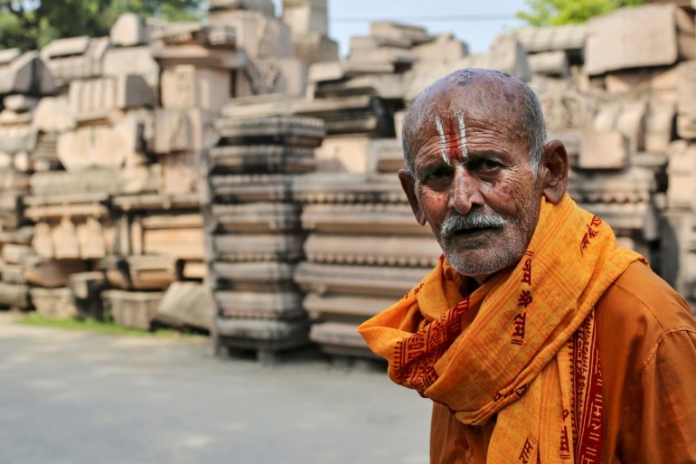 A devotee walks past the pillars that Hindu nationalist group Vishva Hindu Parishad (VHP) say will be used to build a Ram temple at the disputed religious site in Ayodhya, India, October 22, 2019. Picture taken October 22, 2019. REUTERS/Danish Siddiqui