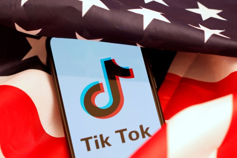 Tik Tok logo is displayed on the smartphone while standing on the U.S. flag in this illustration picture taken, November 8, 2019. REUTERS/Dado Ruvic