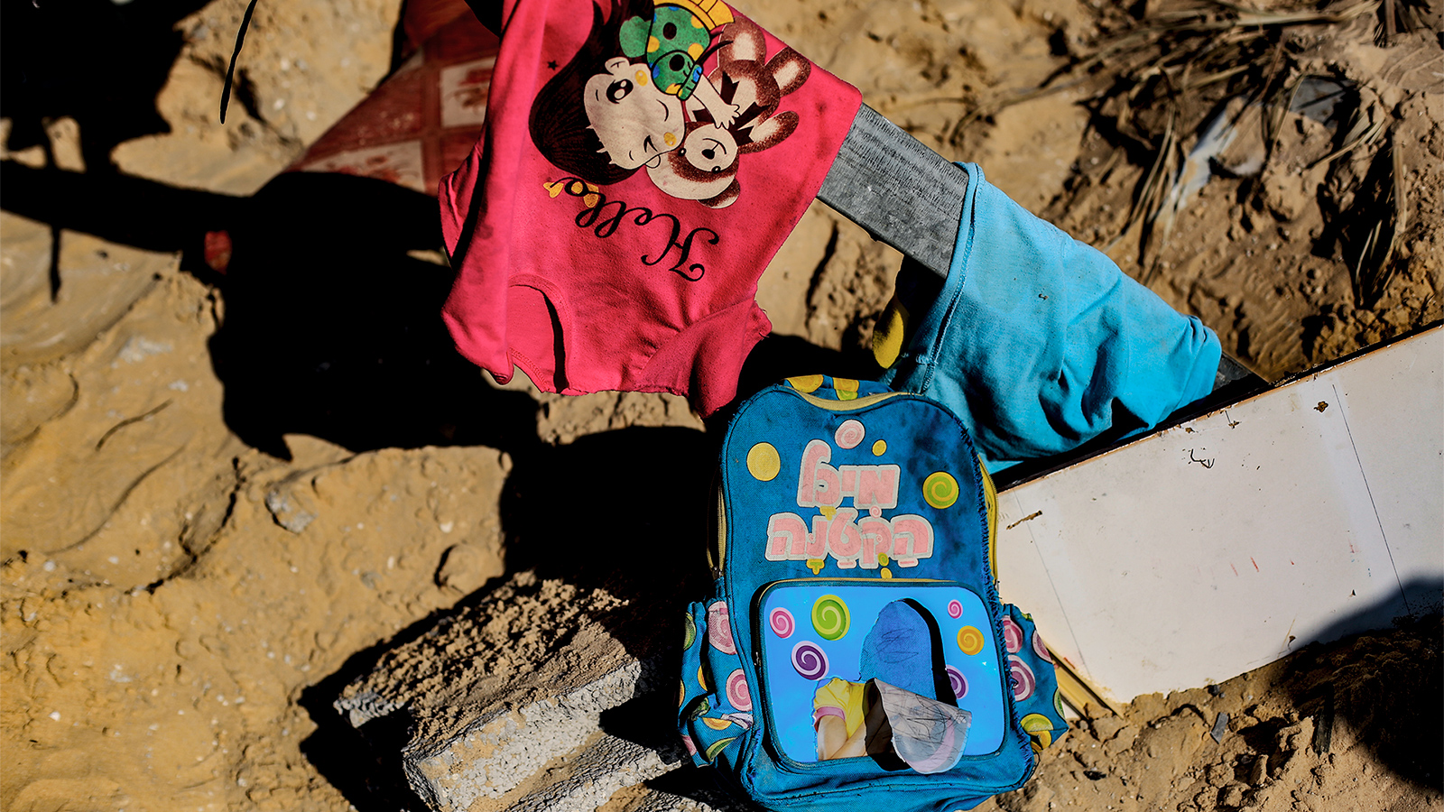 ‪حقيبة مدرسية وملابس طفلة بين ركام منزلي عائلة السواركة‬ (الجزيرة)
