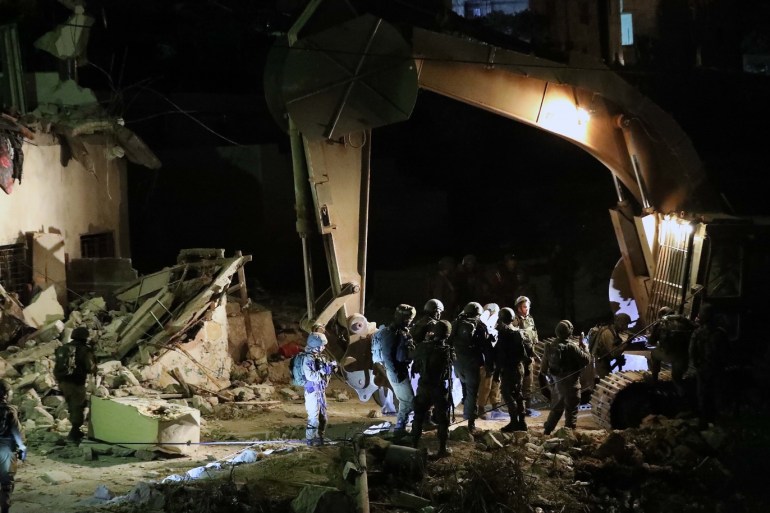 A bulldozer demolishes Palestinian houses in the West Bank village of Biet Kahel near Hebron, 28 November 2019. The Israeli army has allegedly demolished four houses belonging to Palestinian men accused of murdering Israeli soldier in an August, according to a statement issued by the army. EPA-EFE/ABED AL HASHLAMOUN
