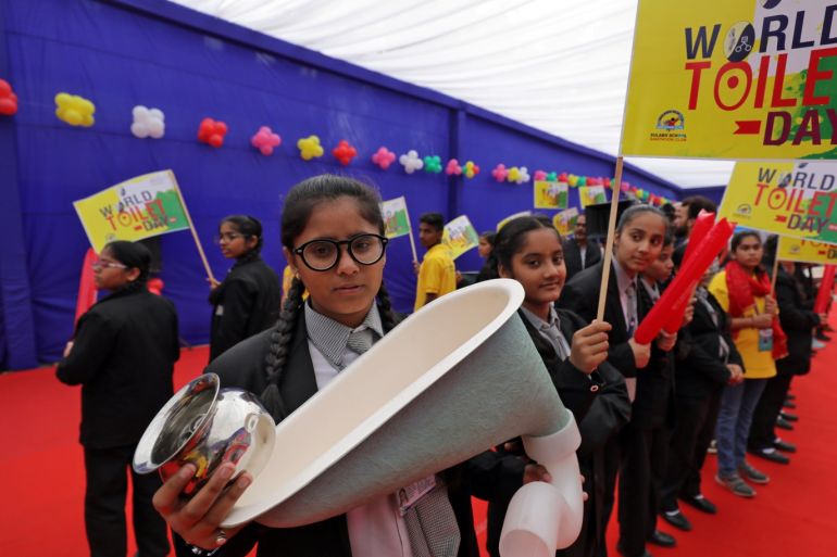 A school girl holds a replica of a toilet pot during an event to mark World Toilet Day in New Delhi, India, November 19, 2018. REUTERS/Anushree Fadnavis