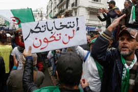 Demonstrators carry a banner and gesture during a protest against the country's ruling elite and rejecting a December presidential election in Algiers, Algeria November 8, 2019. The banner reads