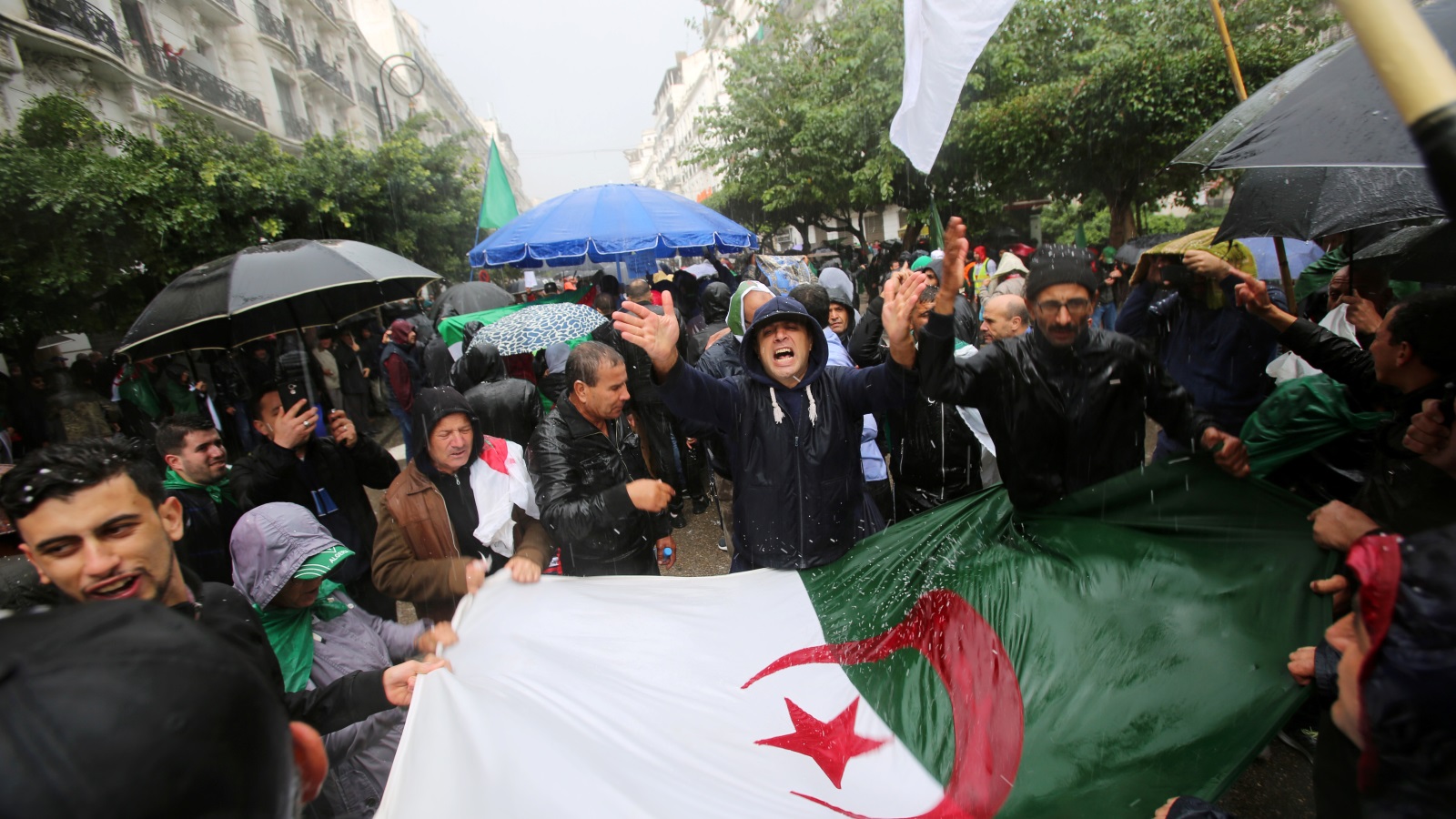 ‪لم تمنع الأمطار متظاهري الجزائر من الخروج أمس‬ (رويترز)