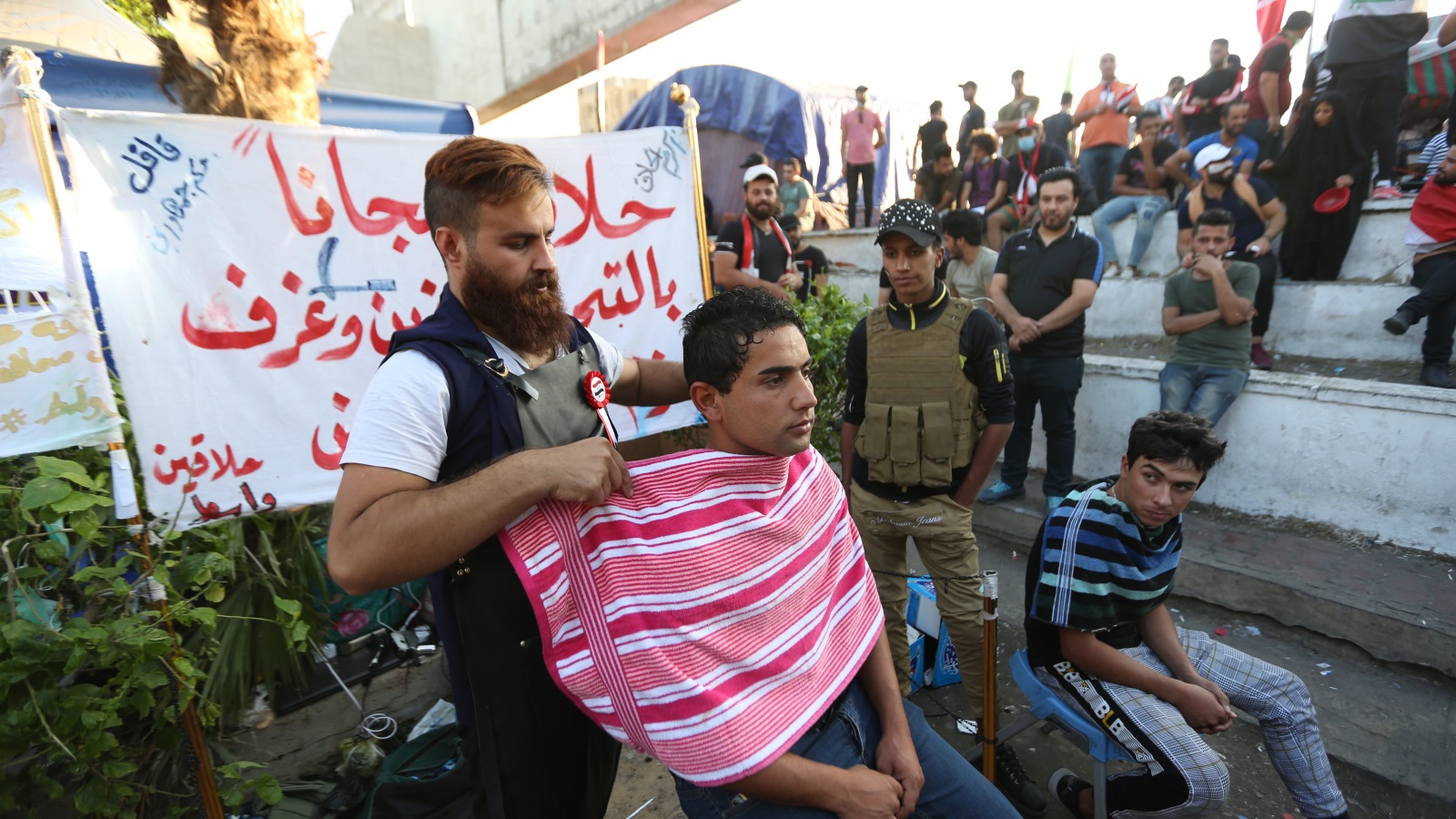 ‪‬ حلاق متطوع بميدان التحرير ببغداد في الخامس من نوفمبر/تشرين الثاني الجاري(الأناضول)