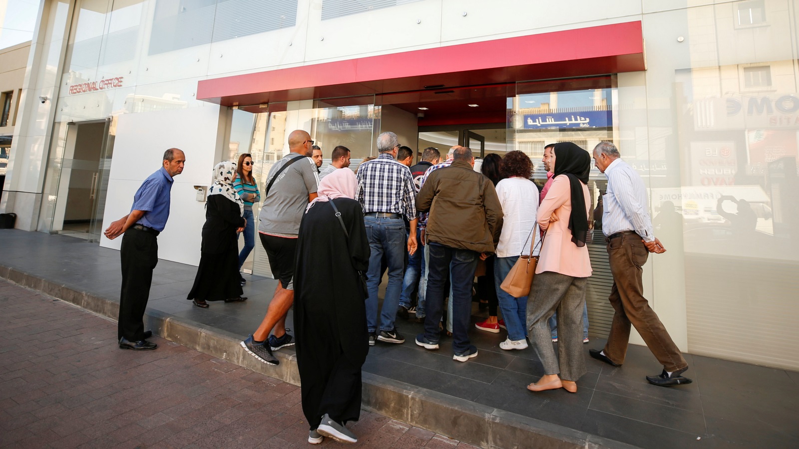‪لبنانيون يدخلون فرع مصرف في مدينة صيدا بعد أسبوع من إغلاق المصارف في عموم البلاد‬ (رويترز)