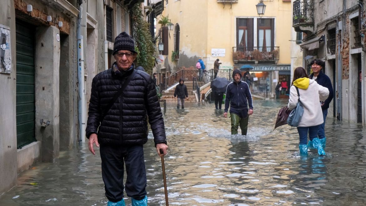 People walk outside during an exceptionally high water levels in Venice, Italy November 13, 2019. REUTERS/Manuel Silvestri