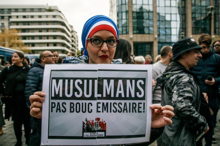 epa07966966 A woman wearing a tricolore veil holds a poster reading 'Muslims but not scapegoat' as protesters gather in front of Cnews TV headquarters to protest against the French polemist and writer Eric Zemmour in Boulogne, near Paris, 02 November 2019. Zemmour was convicted by the courts for racist remarks and is regularly accused of spreading an anti-Muslim speech. EPA-EFE/CHRISTOPHE PETIT TESSON