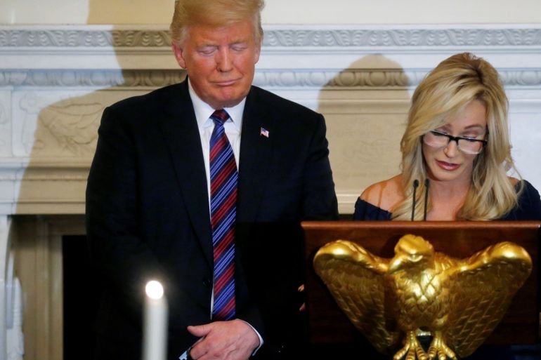 U.S. President Donald Trump closes his eyes as Pastor Paula White leads a prayer at a dinner hosted by the Trumps to honor evangelical leadership in the State Dining Room at the White House in Washington, D.C., U.S. August 27, 2018. REUTERS/Leah Millis