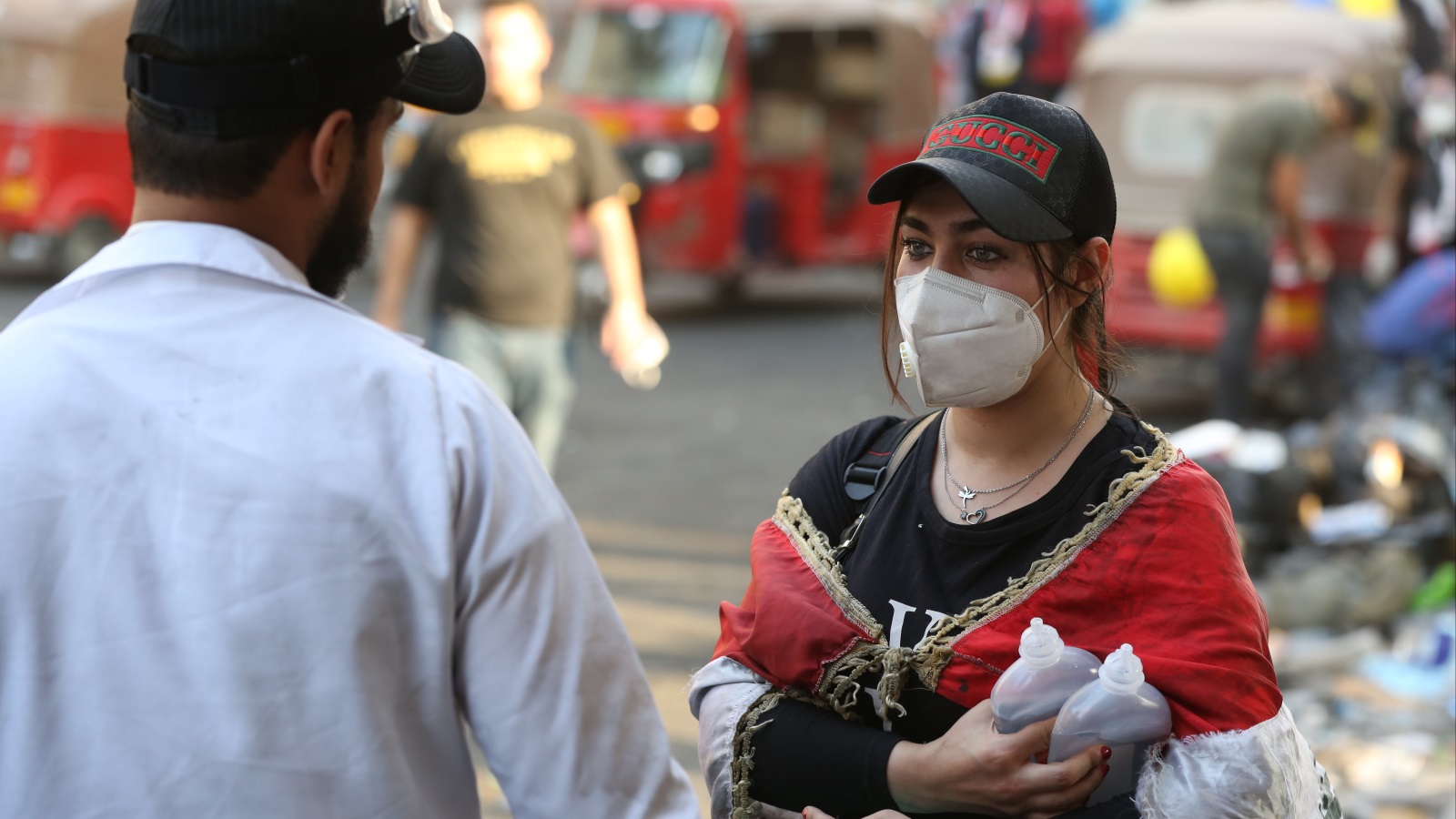شابة عراقية تقدم المساعدة للشباب المتظاهرين في ساحة الخلاني (الأناضول)