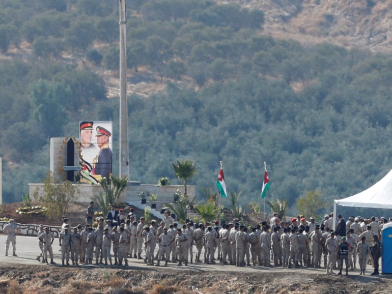 Jordanian soldiers gather near a tent and a picture depicting Jordanian King Abdullah and his father, the late King Hussein, in an area known as Naharayim in Hebrew and Baquora in Arabic, in the border area between Israel and Jordan, as seen from the Israeli side November 11, 2019. REUTERS/Ronen Zvulun