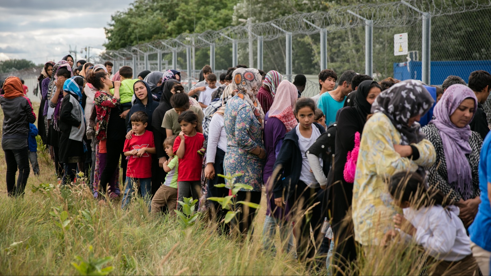 ‪طابور مهاجرين بانتظار معونات إنسانية في مخيم على الحدود بين صربيا والمجر‬ (غيتي)