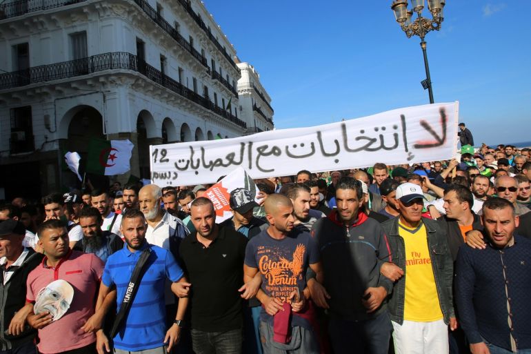 Demonstrators carry a banner during a protest against the country's ruling elite, on the anniversary of the 1954 revolution against French colonial rule, in Algiers, Algeria November 1, 2019. The banner reads: