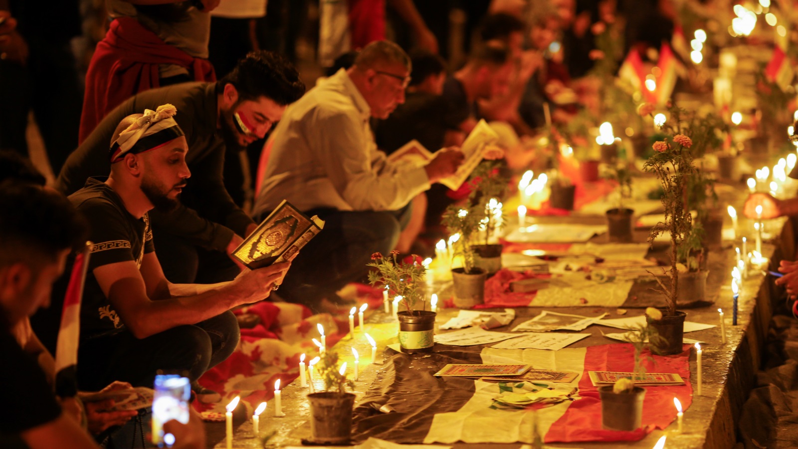 ترتيل للقرآن وإيقاد للشموع تكريما لأرواح من قضى في مظاهرات العراق (رويترز)