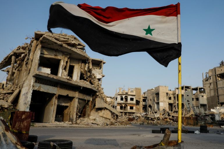 Syrian flag flutters at a military check point in al-Khalidiya area, in the government-controlled part of Homs, Syria, September 18, 2018. In the al-Khalidiya district of Homs, retaken by the government in 2013, after heavy army bombardment and air strikes, the slow nature of recovery is clear. Much of the neighbourhood is a ghost town, uninhabited and closed by the army. REUTERS/Marko Djurica SEARCH