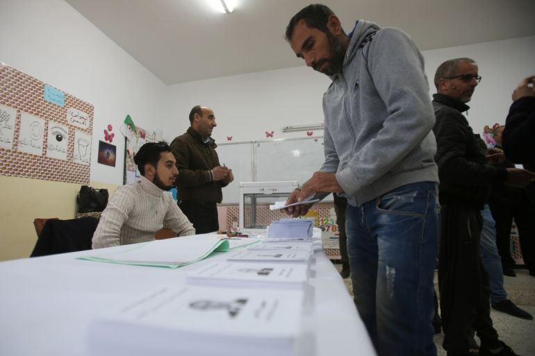 A voter receives ballots at a polling station during the presidential election in Algiers, Algeria December 12, 2019. REUTERS/Ramzi Boudina