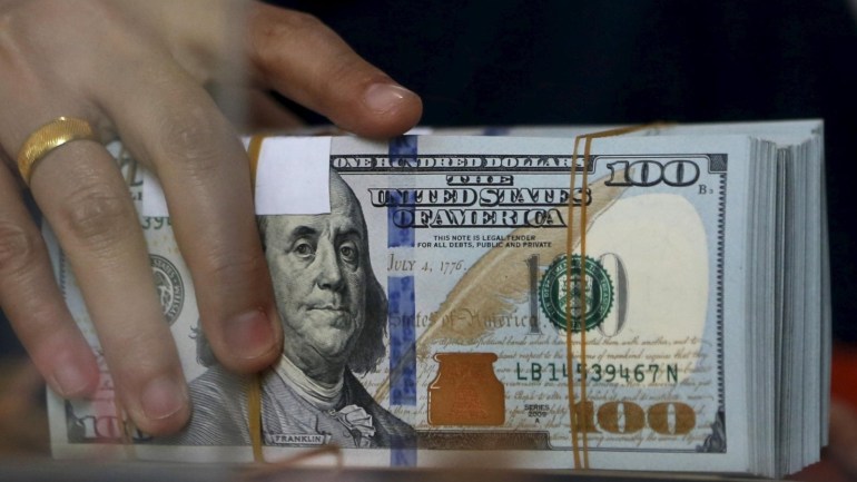An employee of a money changer holds a stack of U.S. Dollar notes before giving it to a customer in Jakarta, October 8, 2015. Most emerging Asian currencies dipped on Thursday as traders booked profits from recent gains and waited on minutes of the Federal Reserve's last policy meeting for any clues on the timing of a U.S. interest rate hike. REUTERS/Beawiharta