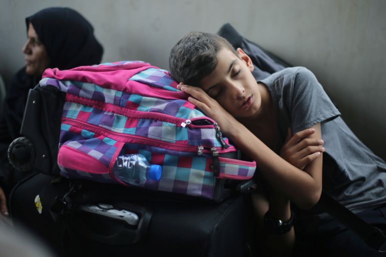 A Palestinian boy sleeps as he waits with his family for a travel permit to cross into Egypt through the Rafah border crossing after it was opened by Egyptian authorities for humanitarian cases, in Rafah in the southern Gaza Strip August 16, 2017. REUTERS/Ibraheem Abu Mustafa