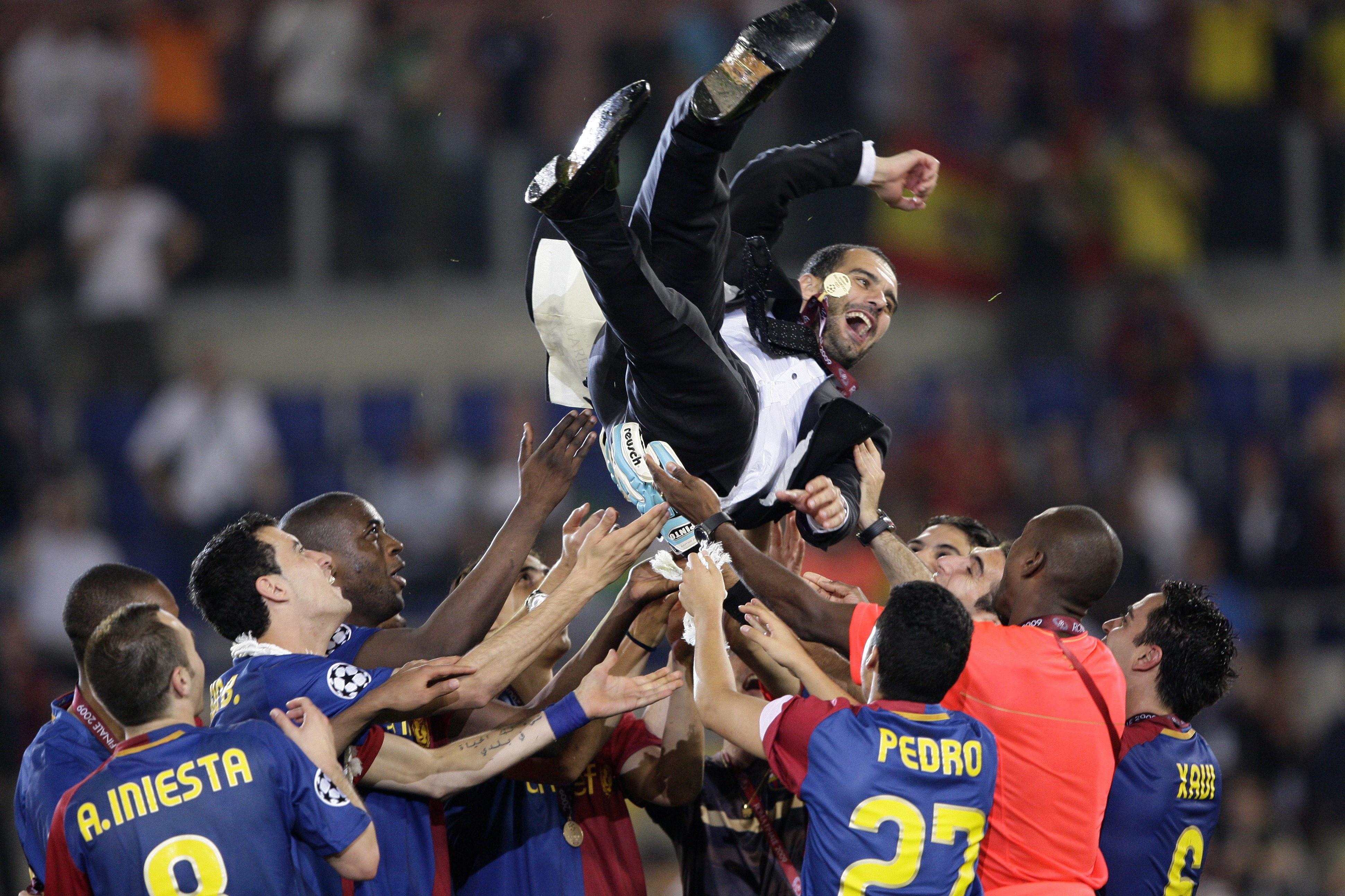 فريق برشلونة يحتفل مع مدرب الفريق بيب غوارديولا (رويترز)