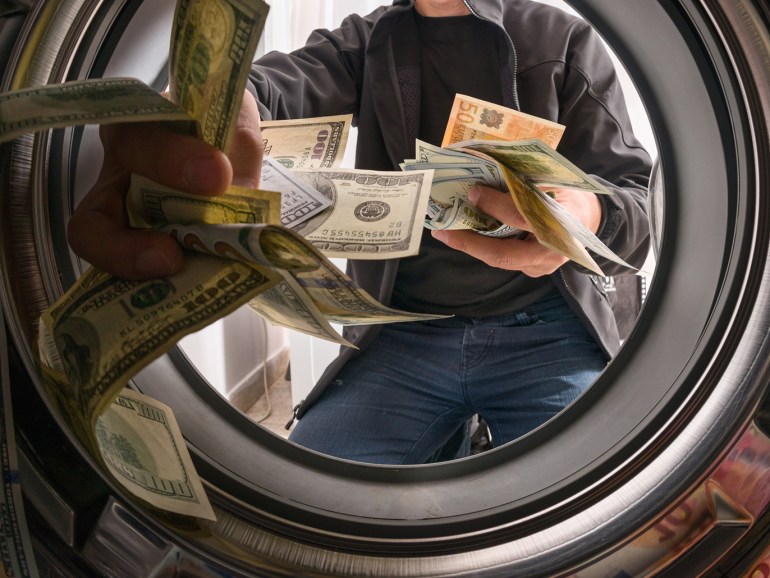 One caucasian male throwing money into a washing machine
