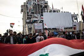 BAGHDAD, IRAQ - NOVEMBER 22: Demonstrators wave a large flag in Tahrir Square on Nov. 22, 2019 in Baghdad, Iraq. Thousands of demonstrators have occupied Baghdad's center Tahrir Square since October 1, calling for government and policy reform. For many, Tahrir Square - which demonstrators are calling