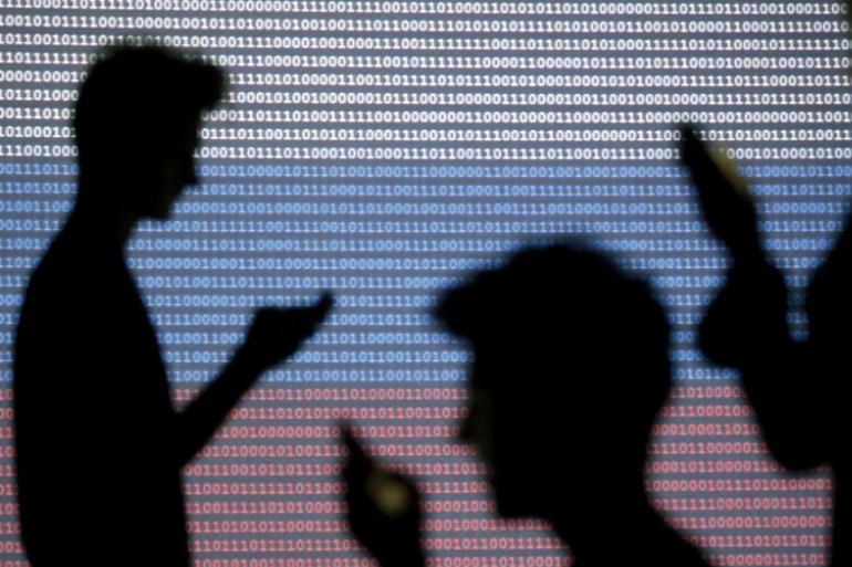 People are silhouetted as they pose with mobile devices in front of a screen projected with a binary code and a Russian national flag, in this picture illustration taken in Zenica October 29, 2014. Facebook Inc warned on Tuesday of a dramatic increase in spending in 2015 and projected a slowdown in revenue growth this quarter, slicing a tenth off its market value. Facebook shares fell 7.7 percent in premarket trading the day after the social network announced an increase in spending in 2015 and projected a slowdown in revenue growth this quarter. REUTERS/Dado Ruvic (BOSNIA AND HERZEGOVINA - Tags: BUSINESS SCIENCE TECHNOLOGY BUSINESS LOGO)
