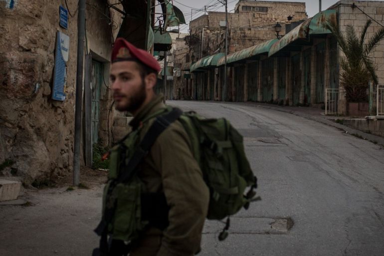 HEBRON, WEST BANK - JANUARY 18: An Israeli soldier stands guard at a checkpoint on a street that seperates an Israeli settlement and a Palestinian neighbourhood inside the city of Hebron on January 18, 2017 in Hebron, West Bank. 70 countries attended the recent Paris Peace Summit and called on Israel and Palestinians to resume negotiations that would lead to a two-state solution, however the recent proposal by U.S President-elect Donald Trump to move the US embassy from Tel Aviv to Jerusalem and last month's U.N. Security Council resolution condemning Jewish settlement activity in the West Bank have contributed to continued uncertainty across the region. The ancient city of Jerusalem where Jews, Christians and Muslims have lived side by side for thousands of years and is home to the Al Aqsa Mosque compound or for Jews The Temple Mount, continues to be a focus as both Israelis and Palestinians claim the city as their capital. The Israeli-Palestinian conflict has continued since 1947 when Resolution 181 was passed by the United Nations, dividing Palestinian territories into Jewish and Arab states. The Israeli settlement program has continued to cause tension as new settlements continue to encroach on land within the Palestinian territories. The remaining Palestinian territory is made up of the West Bank and the Gaza strip. (Photo by Chris McGrath/Getty Images)