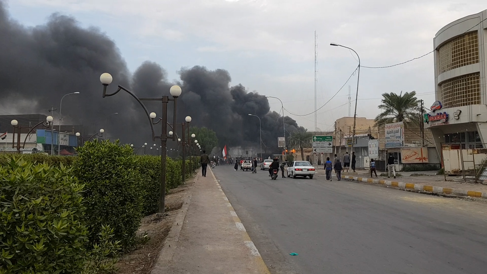 مبنى حكومي في الناصرية يتصاعد منه دخان بعد حرقه (الجزيرة)