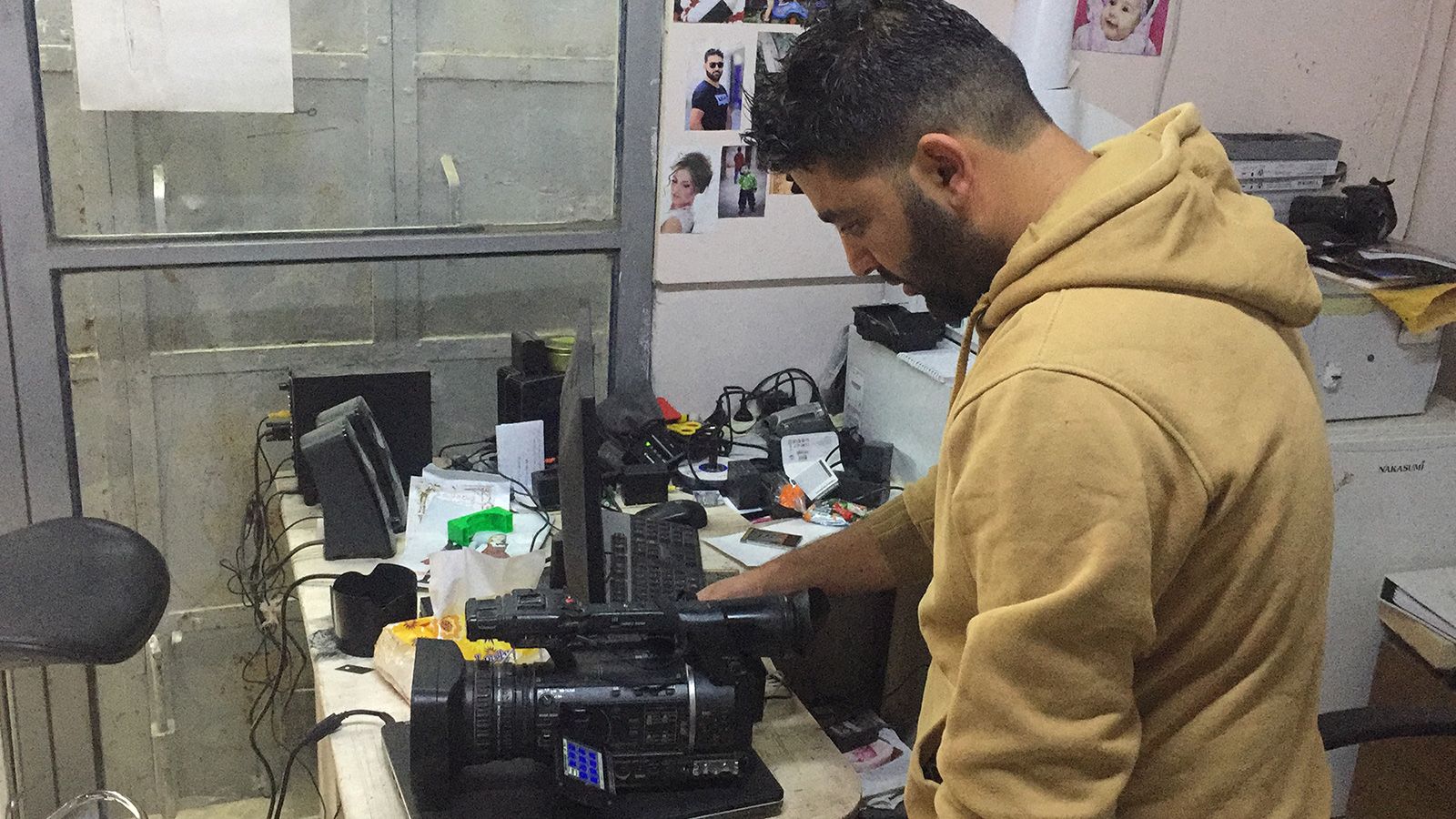 الصحفي الفلسطيني معاذ عمارنة يستعرض آخر صوره قبل انطفاء عينه (الجزيرة)