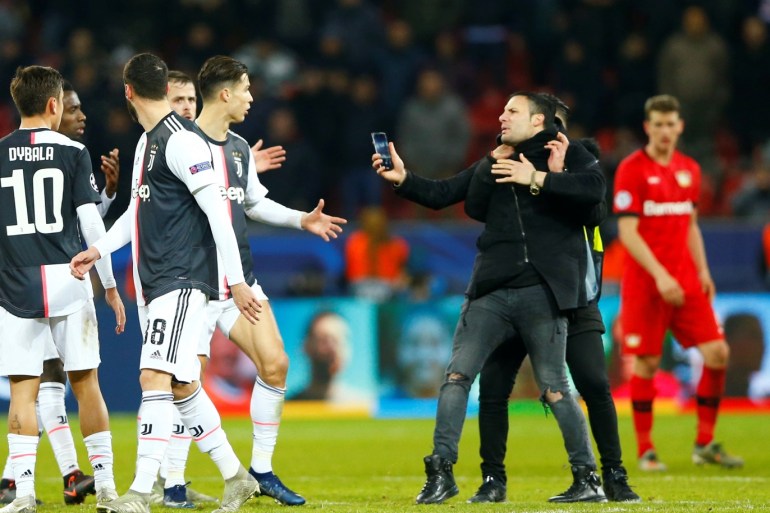Soccer Football - Champions League - Group D - Bayer Leverkusen v Juventus - BayArena, Leverkusen, Germany - December 11, 2019 A pitch invader is apprehended by a steward as Juventus' Cristiano Ronaldo and teammates look on after the match REUTERS/Thilo Schmuelgen
