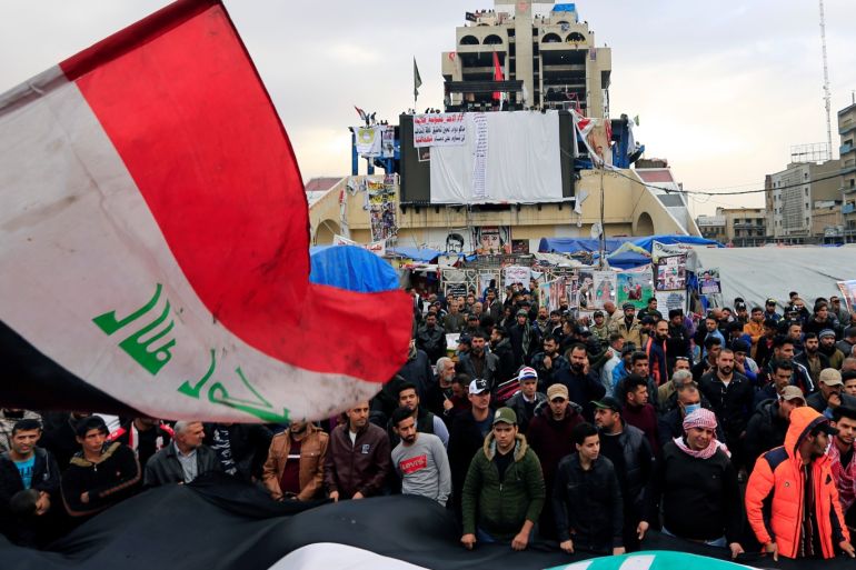 Iraqi demonstrators carry Iraqi flags during ongoing anti-government protests, in Baghdad, Iraq December 27, 2019. REUTERS/Thaier al-Sudani