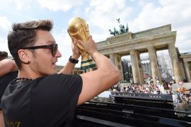BERLIN, GERMANY - JULY 15: Mesut Oezil celebrates on the open top bus at the German team victory ceremony on July 15, 2014 in Berlin, Germany. Germany won the 2014 FIFA World Cup Brazil match against Argentina in Rio de Janeiro on July 13. (Photo by Markus Gilliar - Pool/Getty Images)