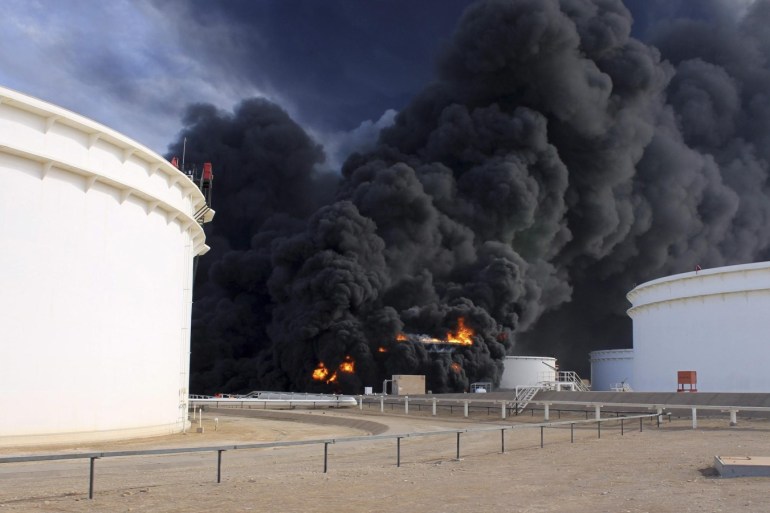 Smoke rises from an oil tank fire in Es Sider port December 26, 2014. A fire at an oil storage tank at Libya's Es Sider port has spread to two more tanks after a rocket hit the country's biggest terminal during clashes between forces allied to competing governments, officials said on Friday. Picture taken December 26, 2014.  REUTERS/Stringer (LIBYA - Tags: CIVIL UNREST ENERGY)
