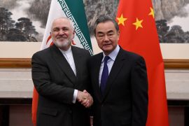 China's Foreign Minister Wang Yi shakes hands with Iran's Foreign Minister Mohammad Javad Zarif during a meeting at the Diaoyutai state guest house in Beijing, China December 31, 2019. Noel Celis/Pool via REUTERS