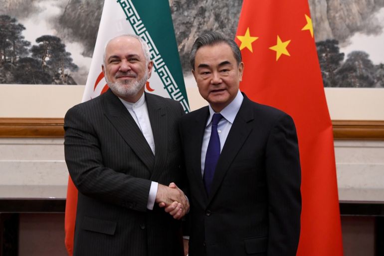 China's Foreign Minister Wang Yi shakes hands with Iran's Foreign Minister Mohammad Javad Zarif during a meeting at the Diaoyutai state guest house in Beijing, China December 31, 2019. Noel Celis/Pool via REUTERS